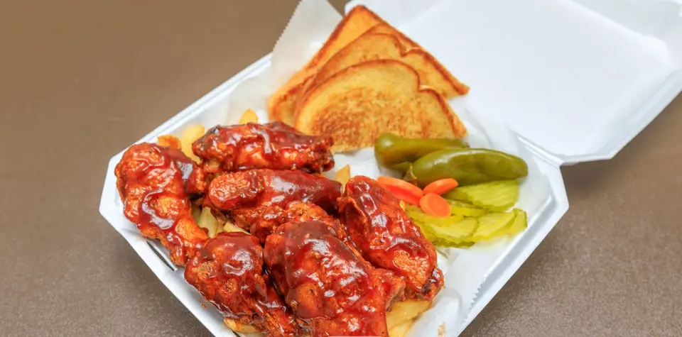 Saucy wings in a takeout basket